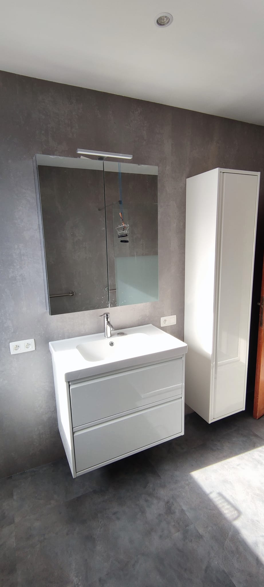 Meuble vasque suspendu blanc miroir éclairé colonne rangement salle de bain moderne murs béton